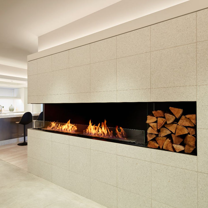 Flex 18LC Modern fireplace with burning logs and stacked firewood on a tiled wall.